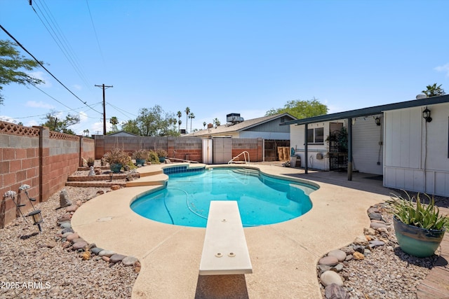 view of swimming pool featuring a fenced backyard, a patio area, and a diving board
