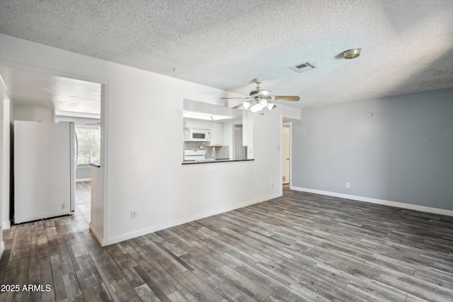 unfurnished living room featuring ceiling fan, wood finished floors, a textured ceiling, and baseboards
