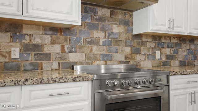 kitchen featuring electric stove, white cabinetry, ventilation hood, and decorative backsplash