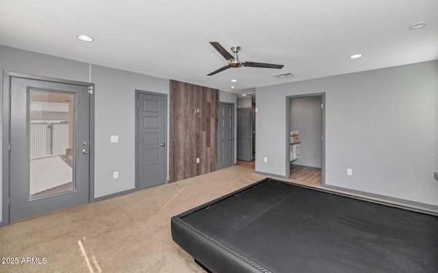 exercise room with light colored carpet and ceiling fan