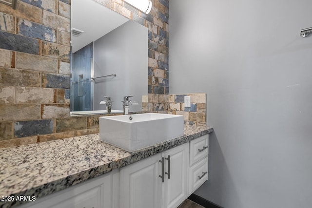 bathroom featuring vanity and decorative backsplash