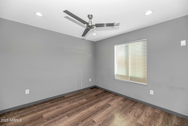 spare room featuring dark wood-type flooring and ceiling fan