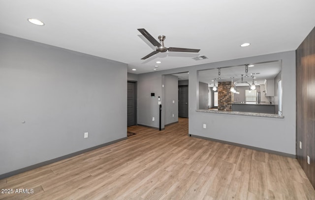 unfurnished living room featuring ceiling fan and light wood-type flooring