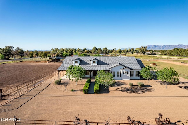 view of front of house with a mountain view and a rural view