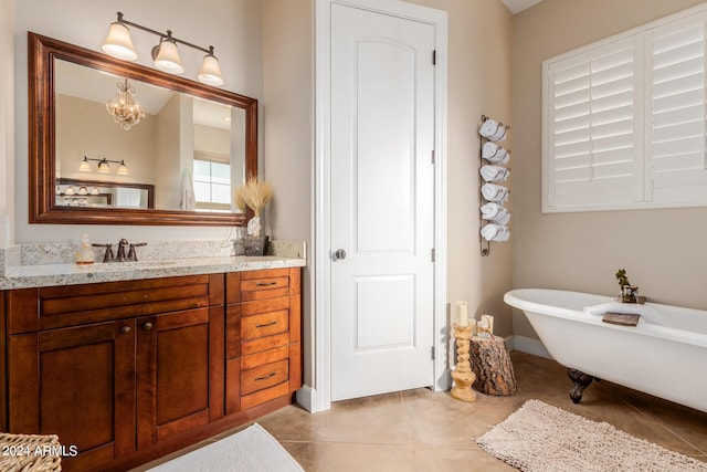 bathroom featuring an inviting chandelier, vanity, a bath, and tile patterned flooring