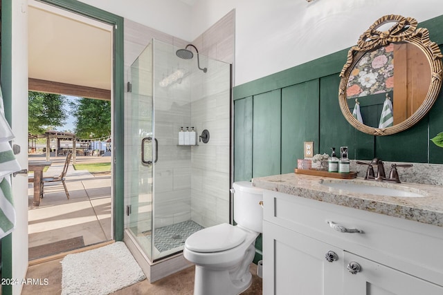 bathroom featuring vanity, toilet, and an enclosed shower