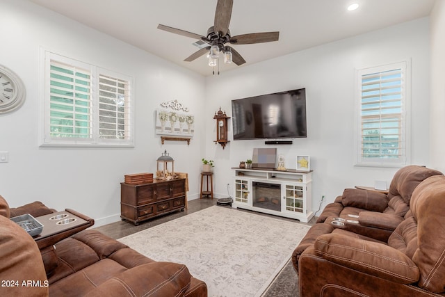 living room featuring hardwood / wood-style flooring, ceiling fan, and a fireplace