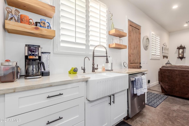 kitchen with dishwasher, sink, white cabinets, and light stone counters