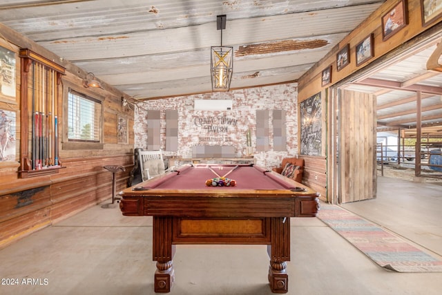 game room featuring lofted ceiling, pool table, and wood walls