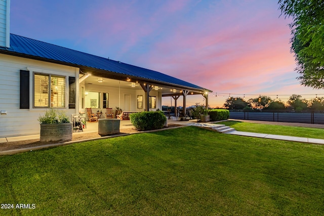 yard at dusk featuring a patio