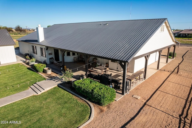 rear view of property with a patio area and a lawn