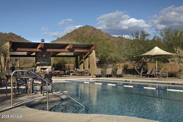 2023 W Yellowbird Ln, Phoenix, AZ 85085 - community pool with a fireplace, a patio, a mountain view, and a pergola