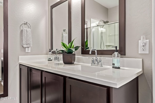 2023 W Yellowbird Ln, Phoenix, AZ 85085 - bathroom featuring double vanity, a shower stall, and a textured wall