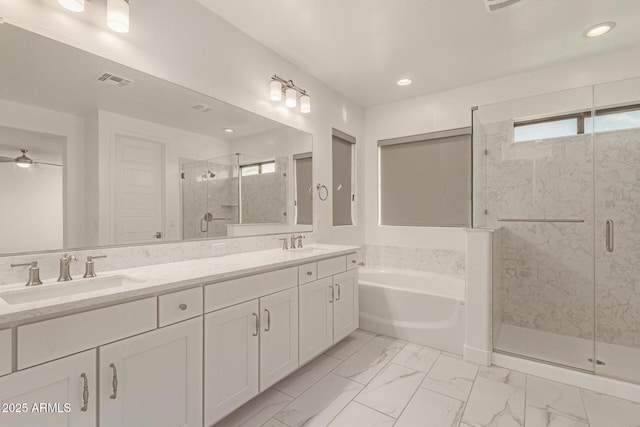 bathroom with visible vents, a sink, a shower stall, and a garden tub