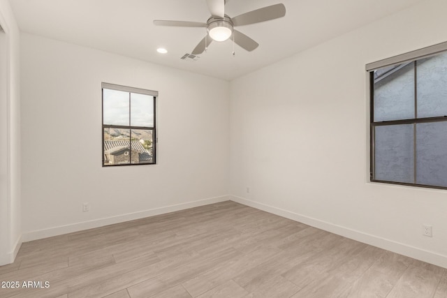 unfurnished room with light wood finished floors, baseboards, and visible vents