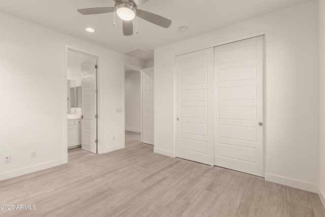 unfurnished bedroom with light wood-type flooring, baseboards, a closet, and ensuite bathroom