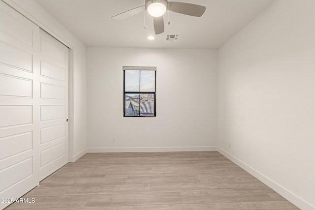 unfurnished bedroom featuring a closet, visible vents, ceiling fan, light wood-type flooring, and baseboards