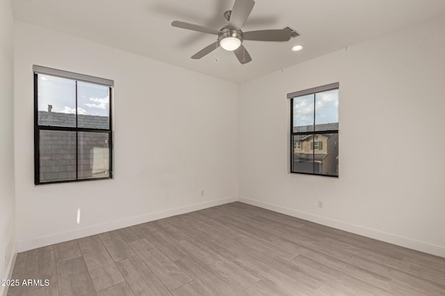 empty room featuring light wood-style flooring, baseboards, a ceiling fan, and recessed lighting