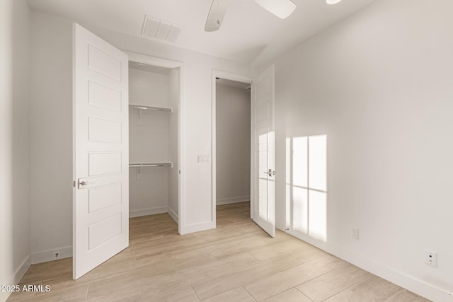 unfurnished bedroom featuring a ceiling fan, visible vents, baseboards, a closet, and light wood-type flooring