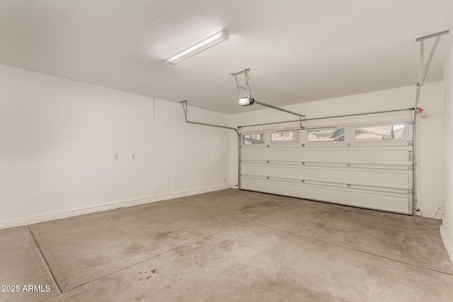 garage with baseboards and a garage door opener