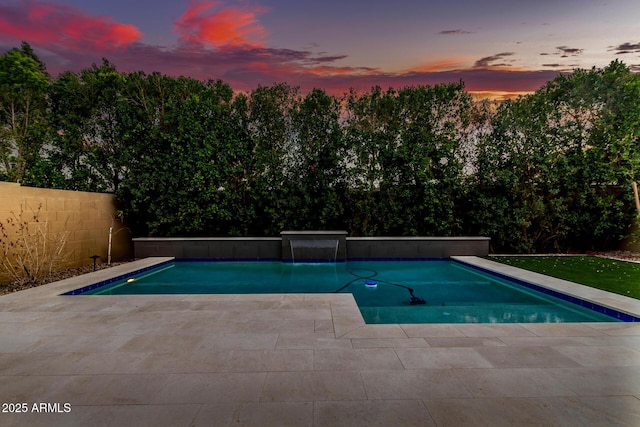 pool with a fenced backyard and a patio