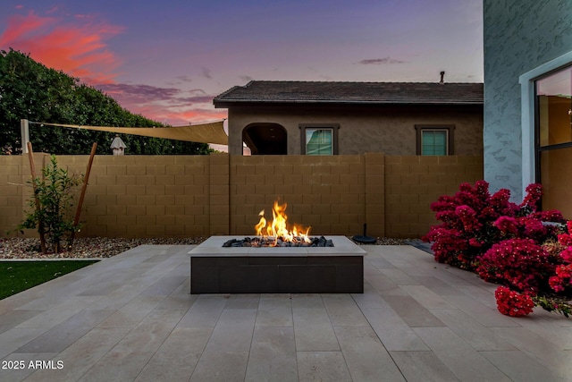 patio terrace at dusk featuring fence