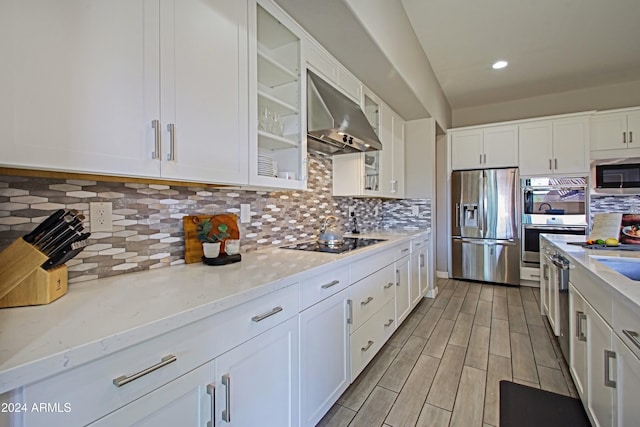 kitchen featuring white cabinetry, backsplash, stainless steel appliances, and exhaust hood