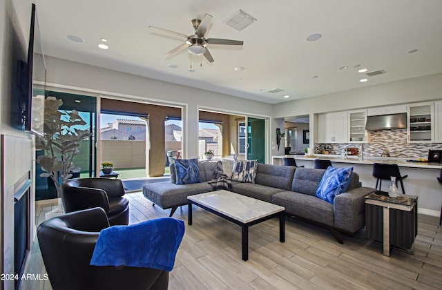 living room featuring light hardwood / wood-style flooring and ceiling fan