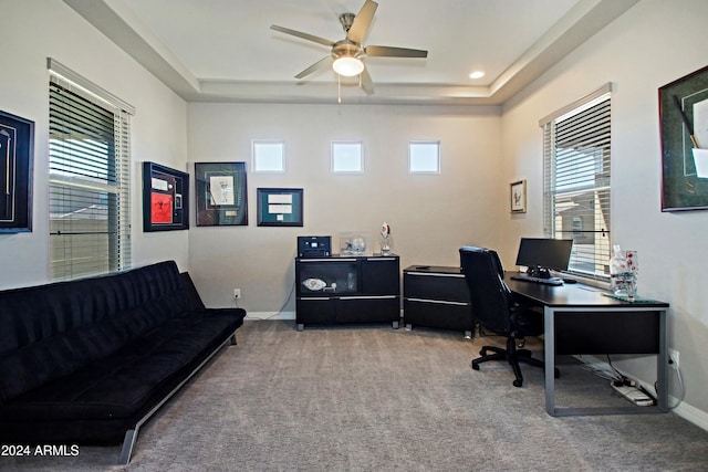 office area featuring carpet floors, a healthy amount of sunlight, a tray ceiling, and ceiling fan