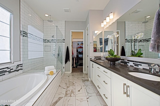 bathroom featuring vanity and independent shower and bath