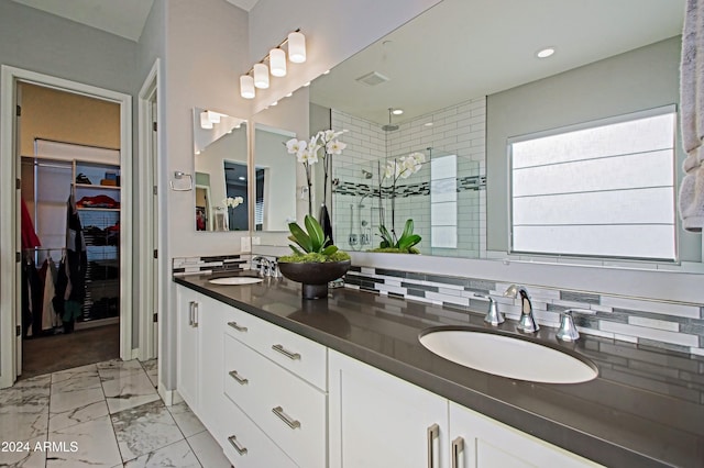 bathroom featuring vanity, backsplash, and a shower with shower door