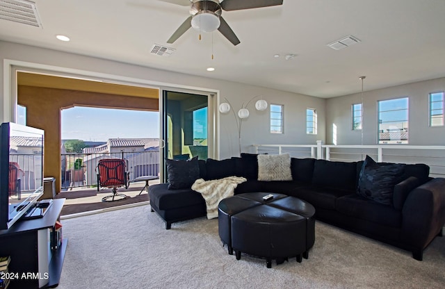 living room featuring ceiling fan, light colored carpet, and plenty of natural light