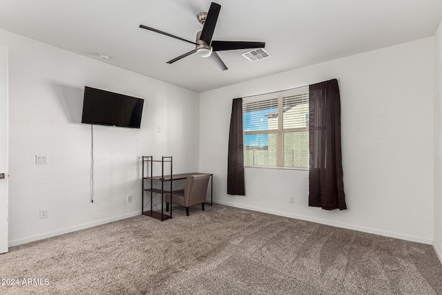 carpeted spare room featuring ceiling fan