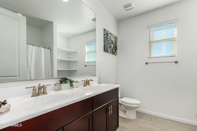 bathroom with hardwood / wood-style floors, vanity, and toilet