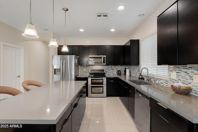 1502 E Goldcrest St, Gilbert, AZ 85297 - kitchen featuring appliances with stainless steel finishes, dark cabinets, a sink, decorative backsplash, and light countertops