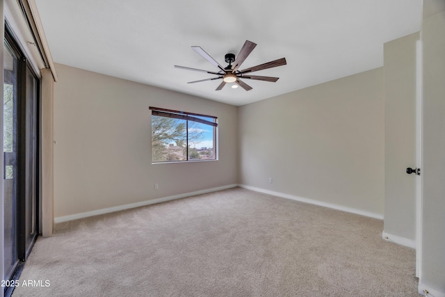 carpeted spare room with baseboards and ceiling fan