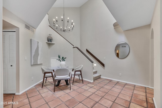 dining space featuring a towering ceiling, visible vents, stairway, baseboards, and an inviting chandelier