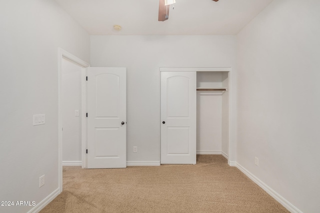 unfurnished bedroom featuring light colored carpet, ceiling fan, and a closet