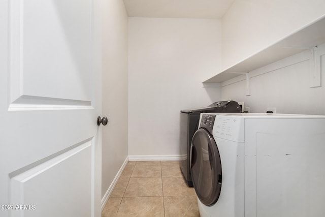 laundry area with light tile patterned floors and washing machine and dryer