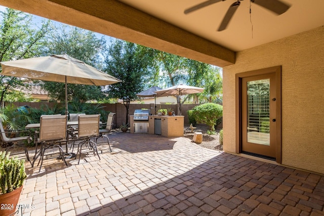 view of patio / terrace with ceiling fan, a grill, and exterior kitchen