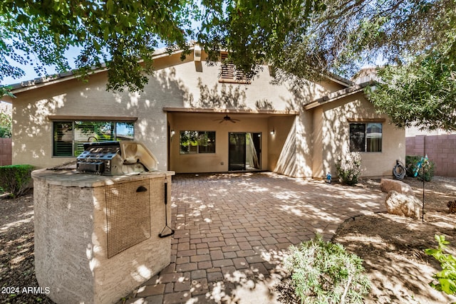 rear view of house with ceiling fan, area for grilling, and a patio