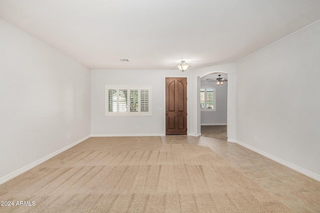 tiled spare room with ceiling fan