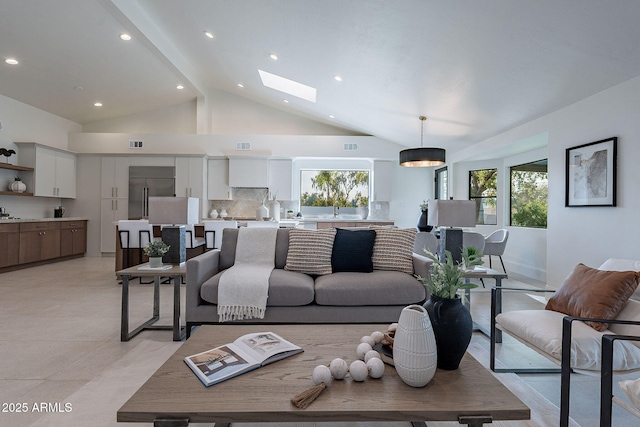 living room featuring high vaulted ceiling and a skylight