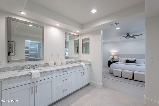 bathroom with a raised ceiling, tile patterned floors, ceiling fan, and vanity