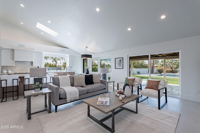 living room featuring sink, high vaulted ceiling, and a skylight