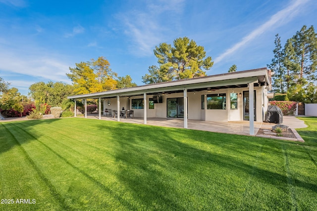 back of house featuring a patio area, a lawn, and ceiling fan