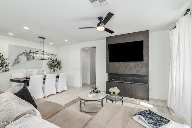 living area with ceiling fan with notable chandelier, recessed lighting, visible vents, and tile patterned floors