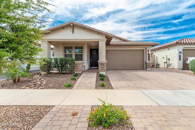 view of front of home with a garage, decorative driveway, stone siding, and stucco siding