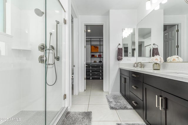 full bath with a sink, double vanity, a stall shower, and tile patterned flooring