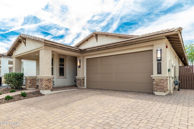 single story home with an attached garage, stone siding, and stucco siding